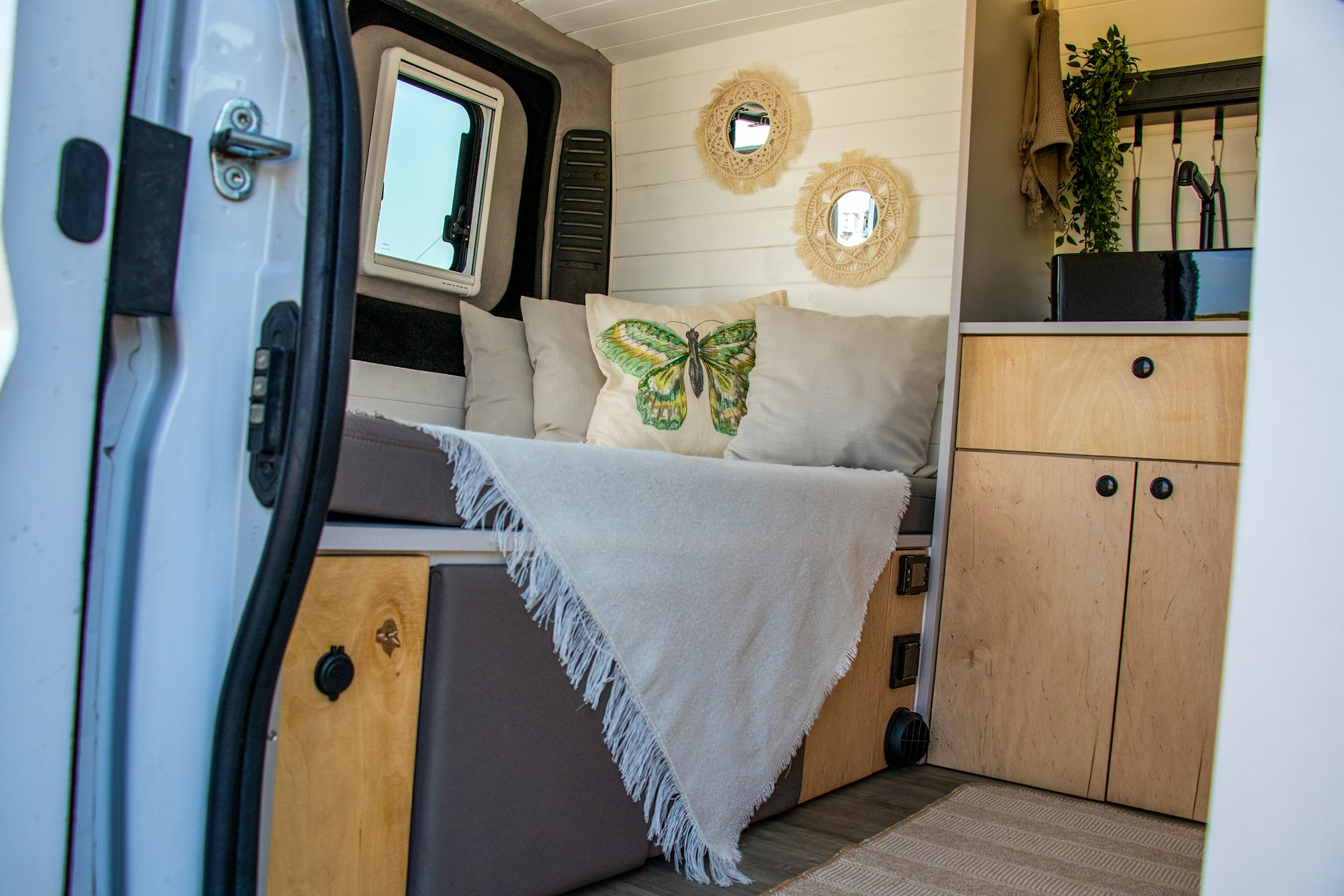 a bed inside of a trailer with a white blanket on top of it